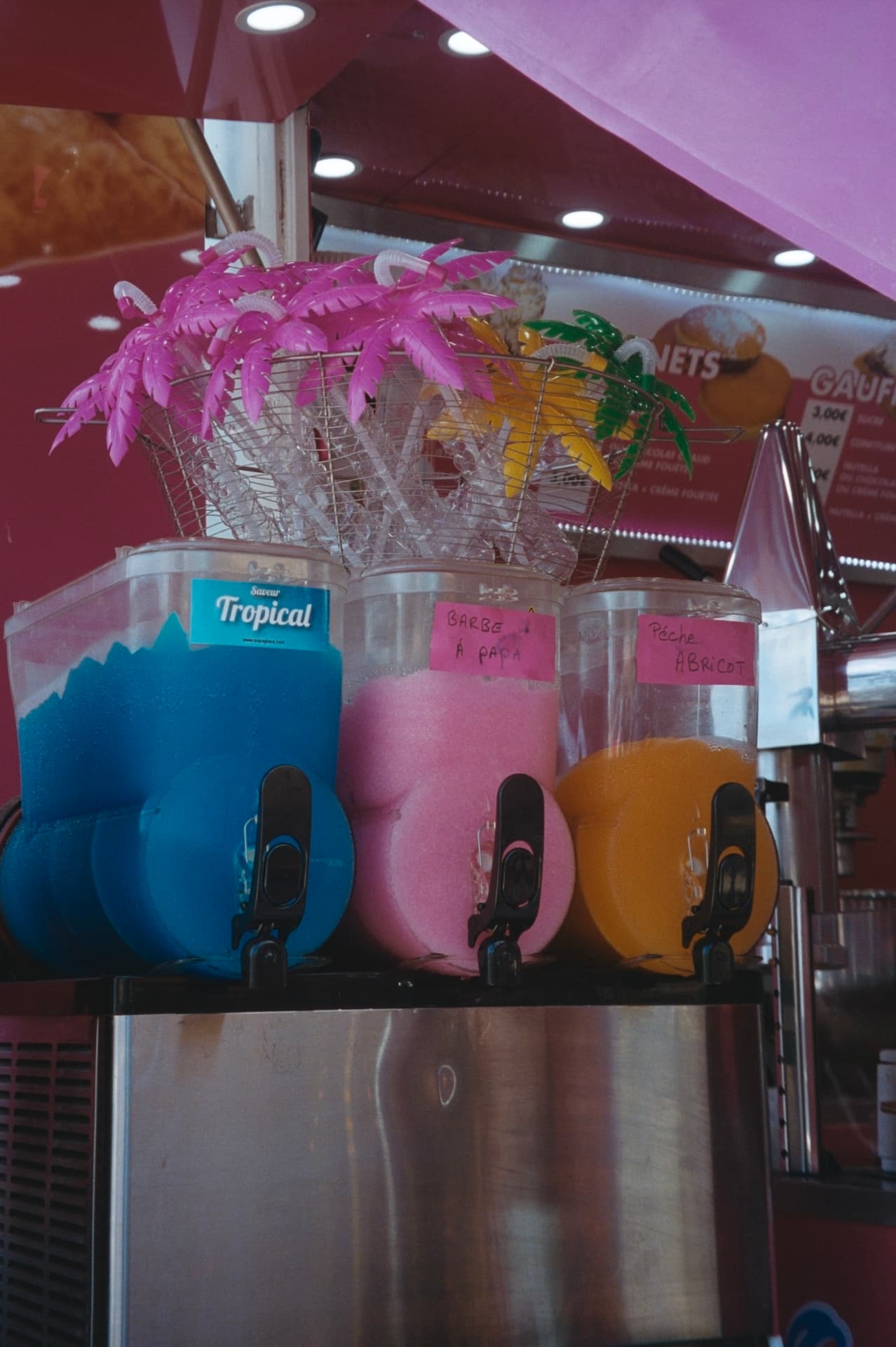 granita machines in pink, blue and orange at a beach stand
