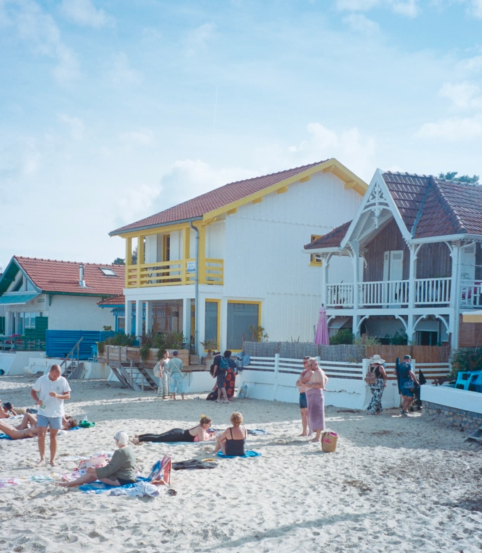 painted beach houses and people on the sand in cap ferret