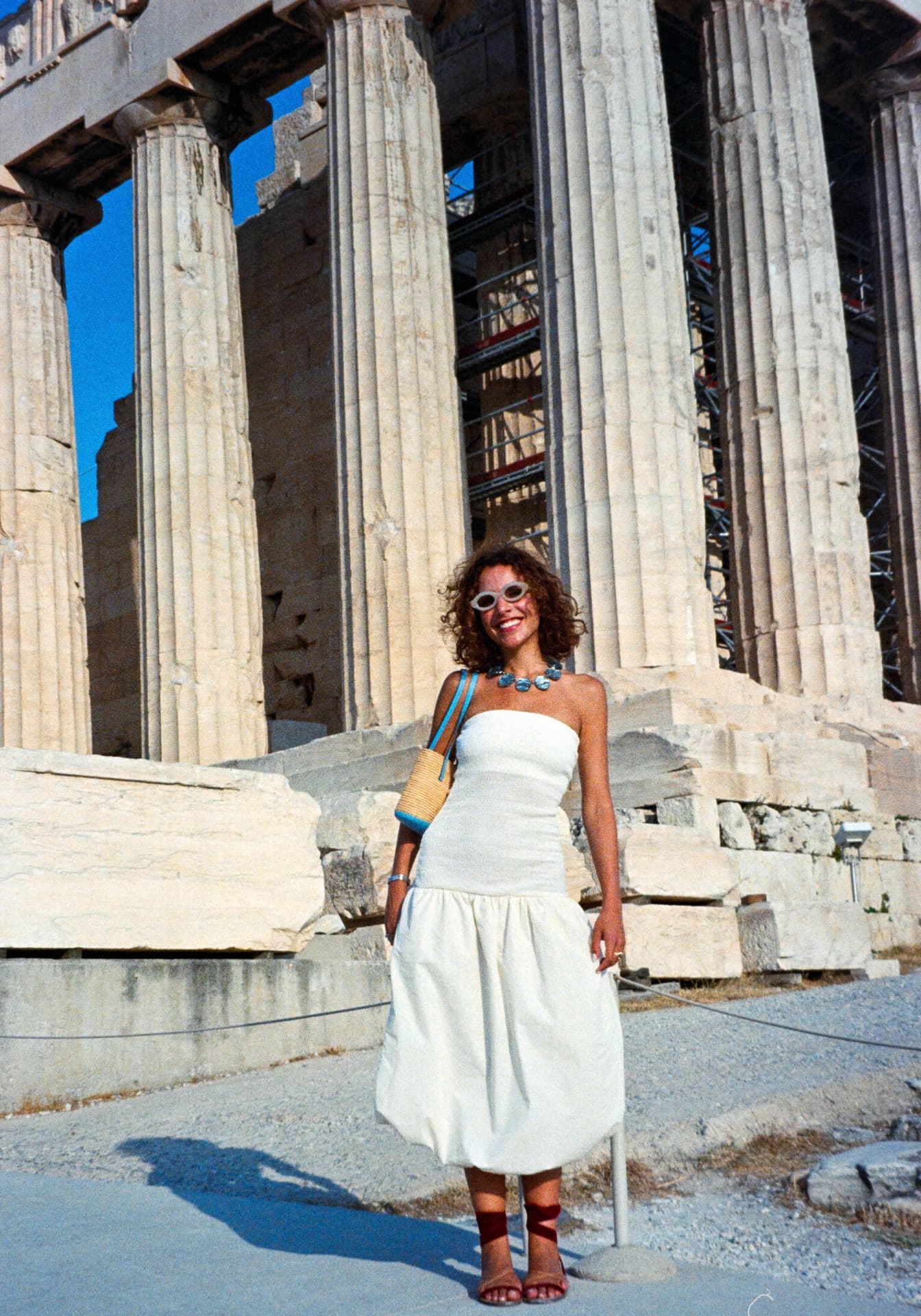 natalia in a white dress in front of the parthenon in athens
